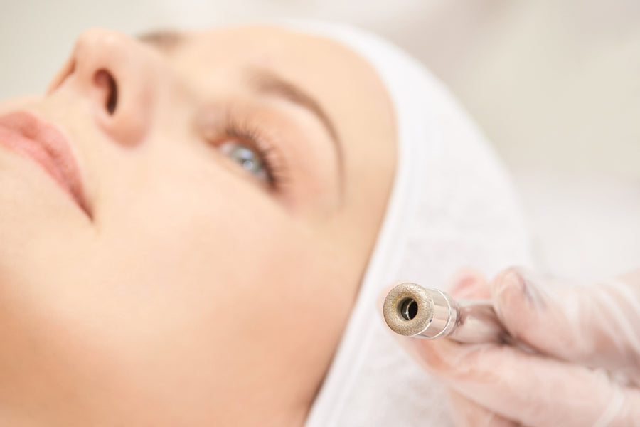 Kosmetikerin führt eine professionelle Mikrodermabrasion im Gesicht einer entspannten Kundin durch.